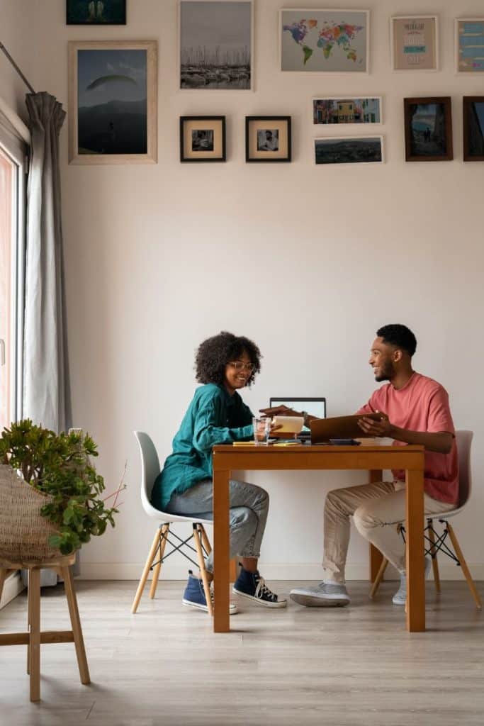 smiling couple working on budget at table