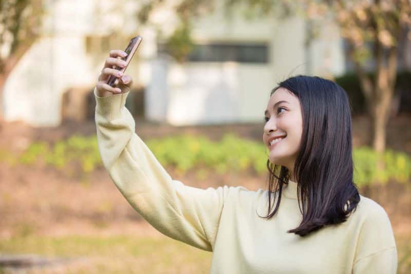 young woman using mobile phone to take a selfie
