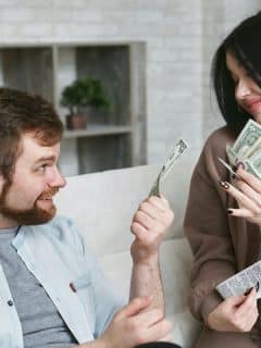 young man and woman holding money