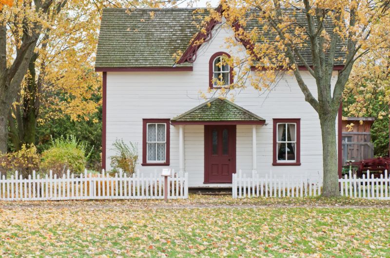 cute white home with red door and trim and white picket fence