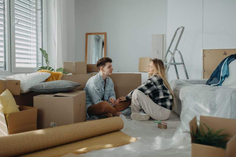young couple surrounded by boxes on moving day