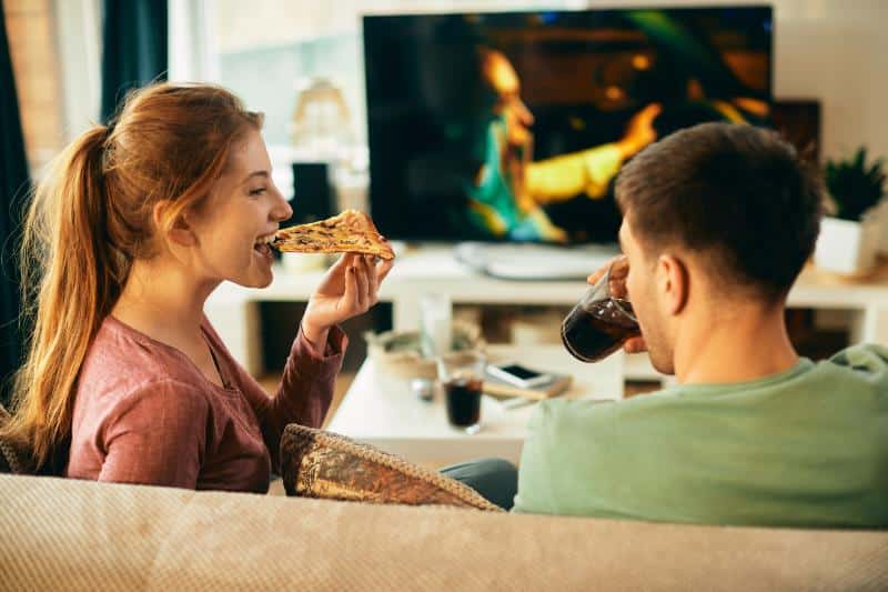 couple watching tv and eating