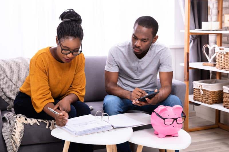 couple sitting on sofa working on budget