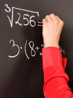 hand writing math problems on chalkboard