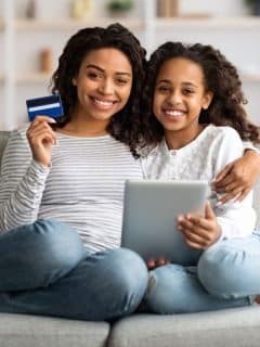 mother and daughter shopping online with credit card and tablet