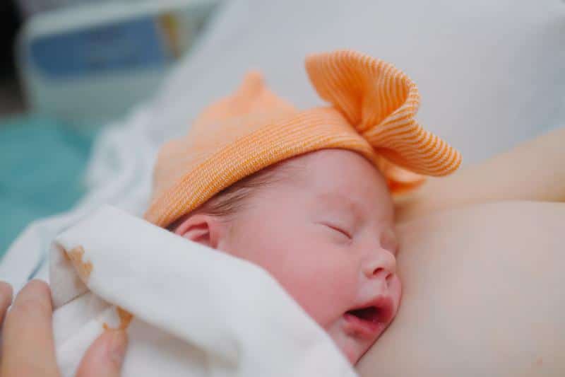 newborn baby with orange bow