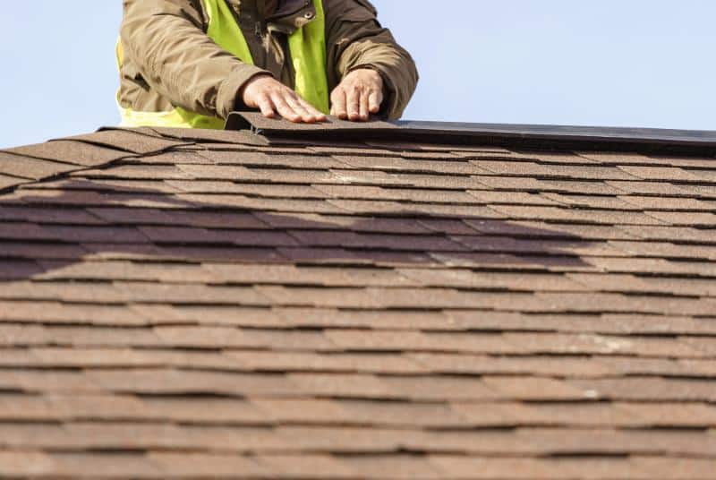 worker installing materials on roof