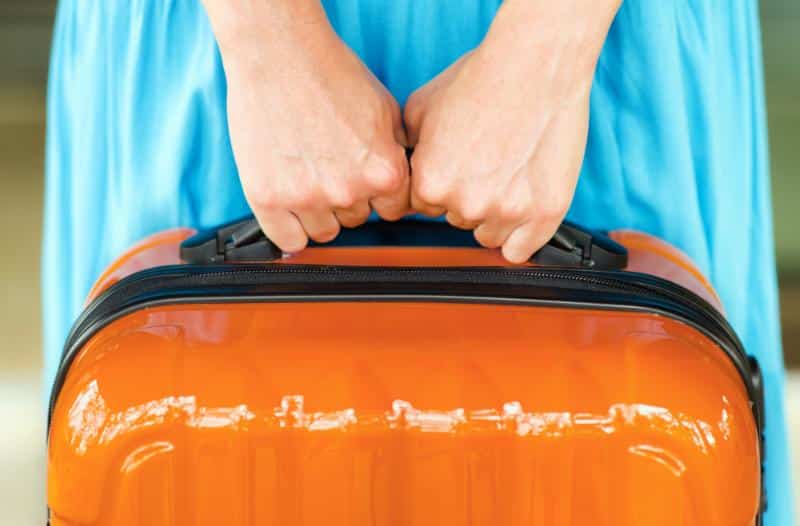 woman with hard orange suitcase