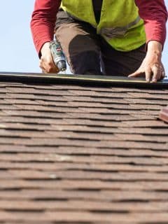 worker using tools on roof