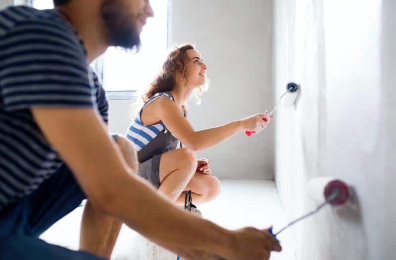 young couple painting a wall