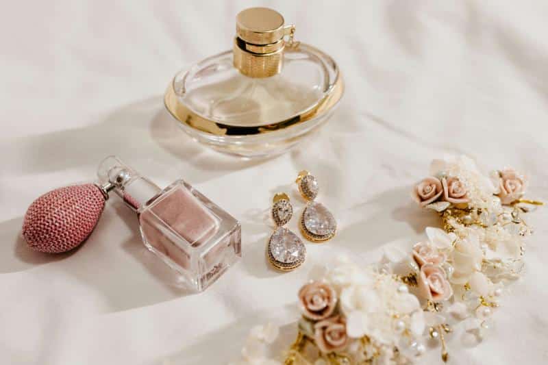 bottles of perfume with earrings and a floral accessory