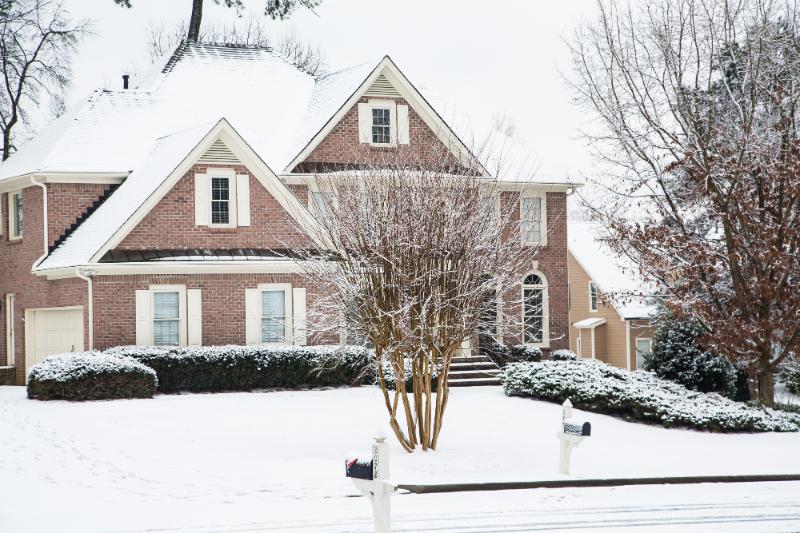 brick home in the winter with snow