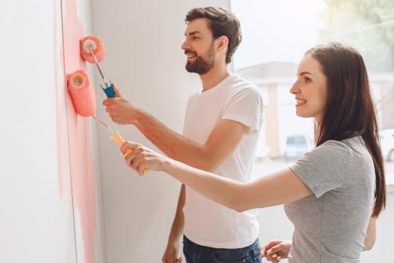 couple painting a room pink