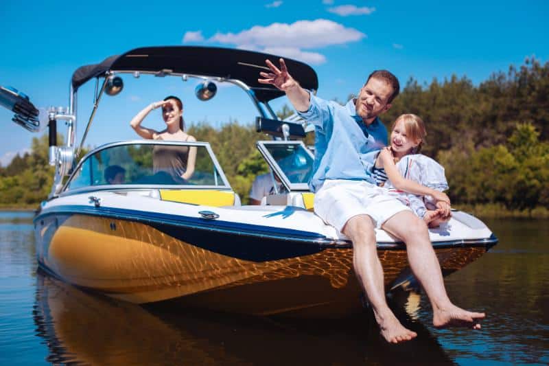 family on a boat, father and daughter on front looking into distance