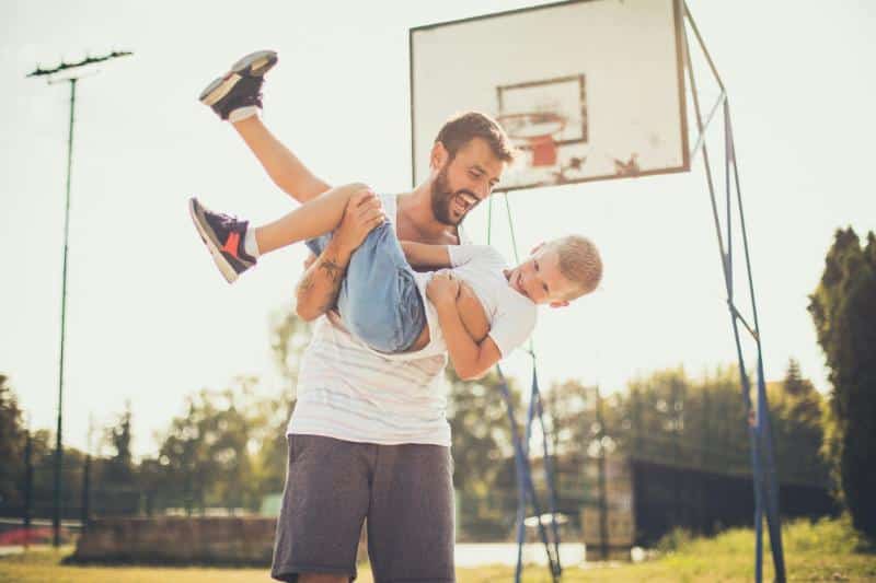 father and son in front of basketball goal