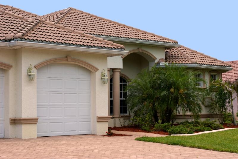 stucco home with clay tile roof