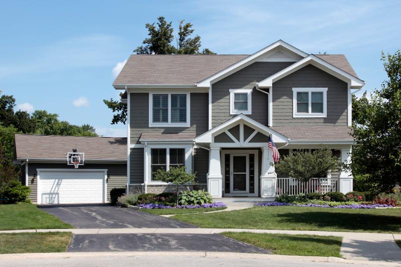 gray suburban home with shingled roof