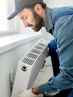 man installing a radiator heater