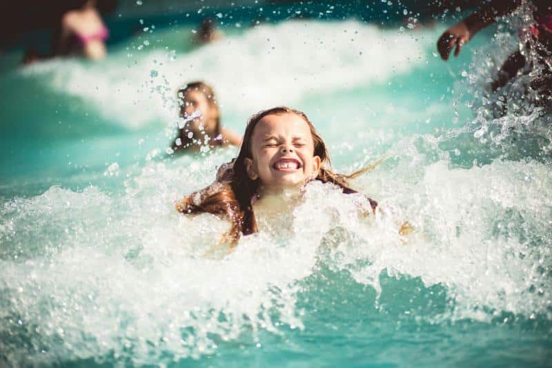 girl making a big splash after jumping in pool