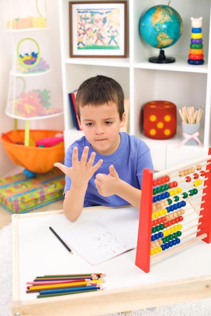 little boy working out a math problem