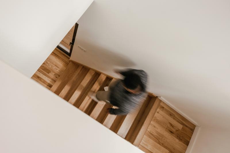 man going down wooden staircase - slightly blurry image