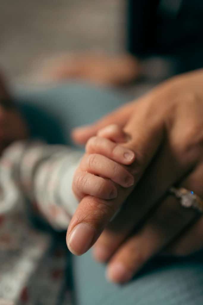 baby's hand grasping mother's finger