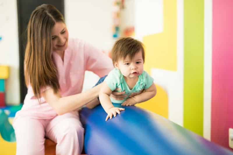 therapist working with baby on balance