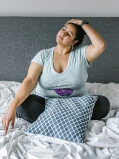 plus size woman relaxing on bed in loungewear