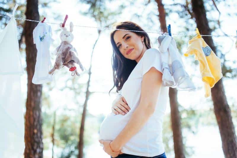 pregnant woman holding belly outdoors
