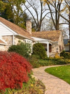 pretty house in the fall with winding sidewalk