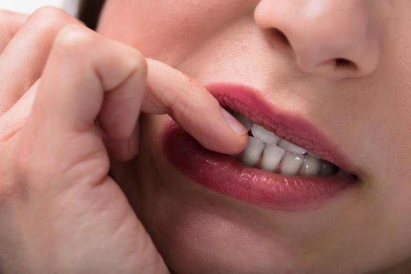 closeup of woman biting nails