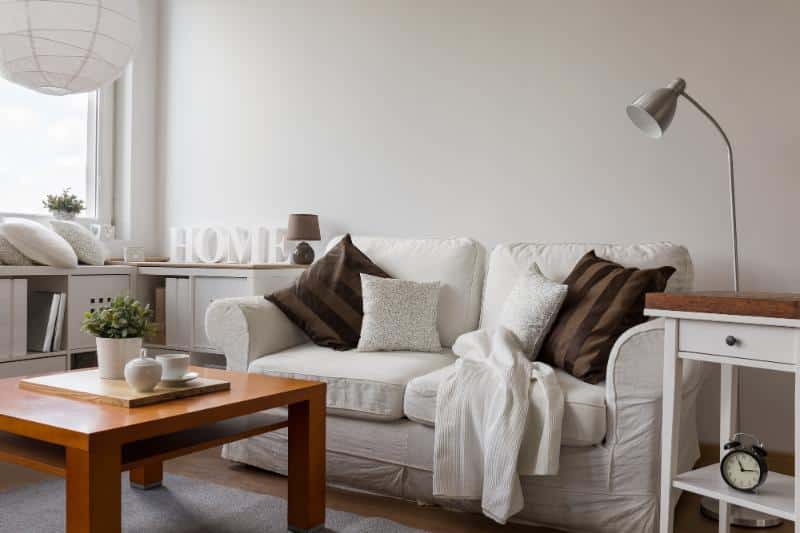 living room with white couch, decorative throw pillows, table, and other home decor