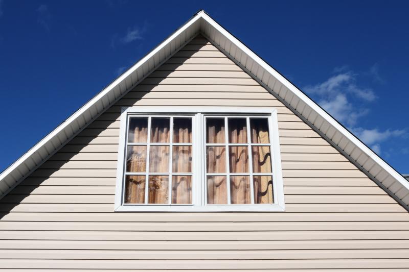 looking up at window and roof - house with tan siding