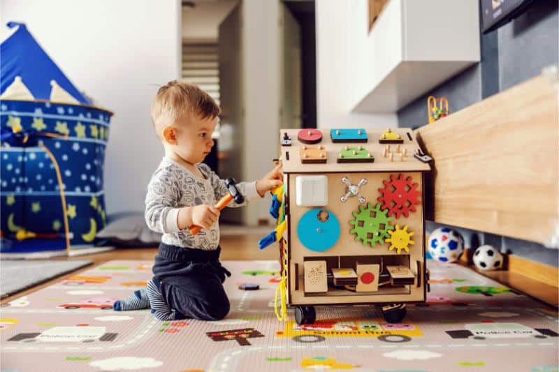 toddler boy playing with toys in playroom