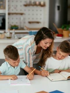 mother helping her two boys with homework