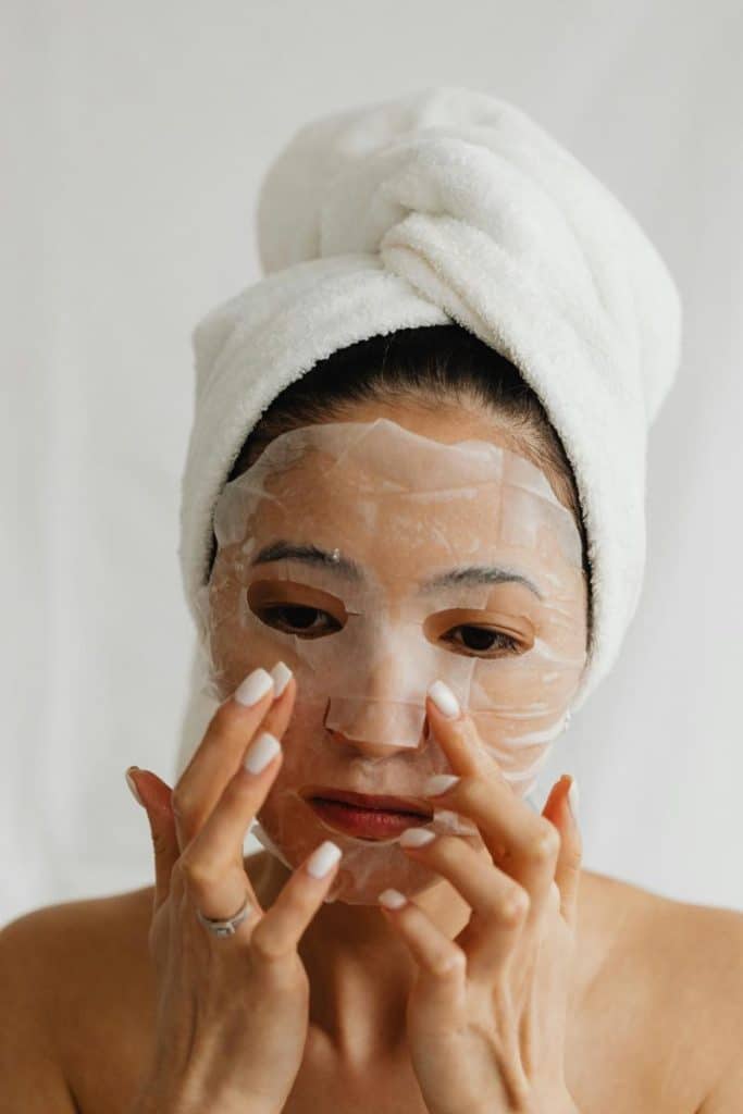 woman applying mask to face