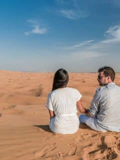 couple sitting in desert in dubai