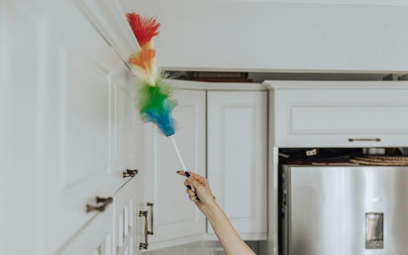 using rainbow feather duster to clean cabinets