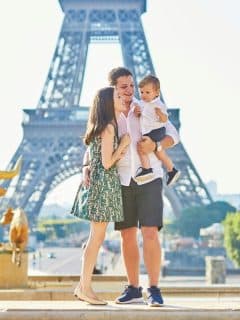 mom, dad, toddler boy standing in front of eiffel tower