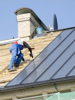 man installing a metal roof