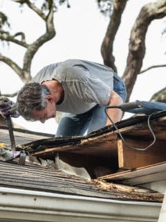 man looking at a leaky roof to make repairs