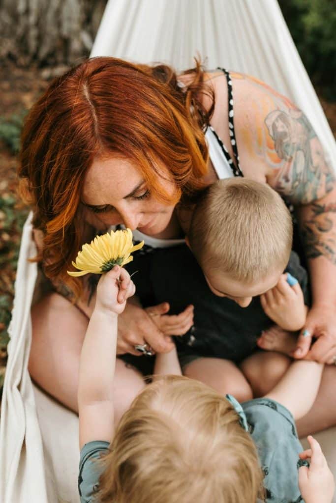 red-haired woman in hammock with her children