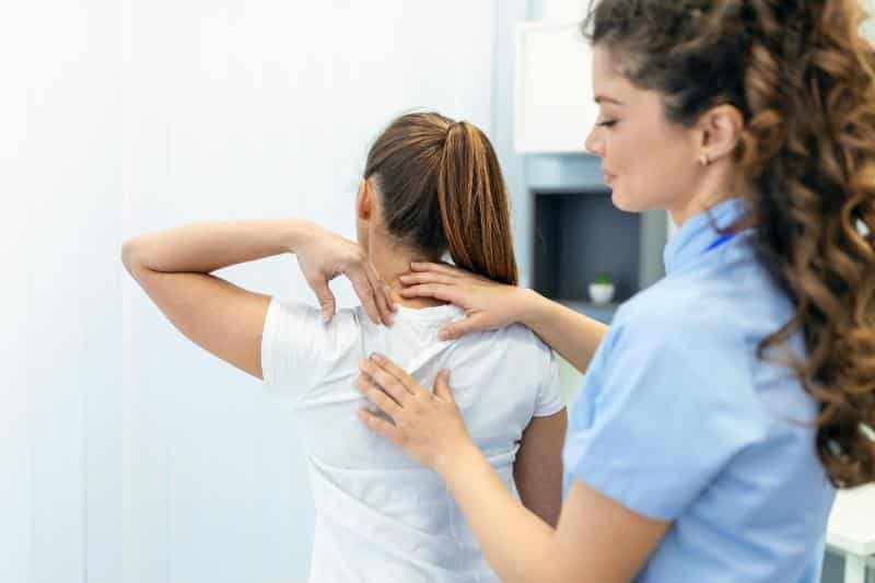 physical therapist massaging woman's shoulder