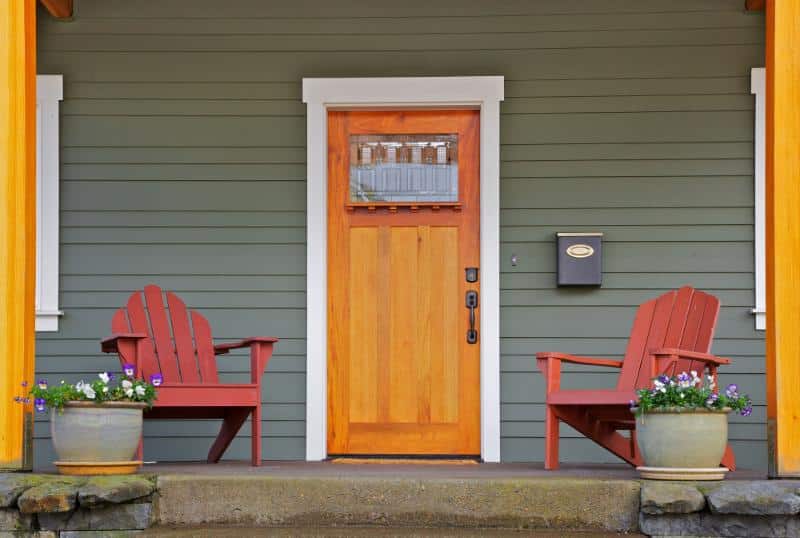wooden door with Adirondack chairs on either side