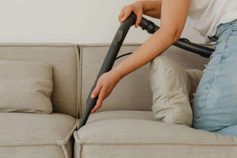 woman vacuuming a couch