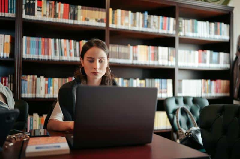 woman in library with laptop