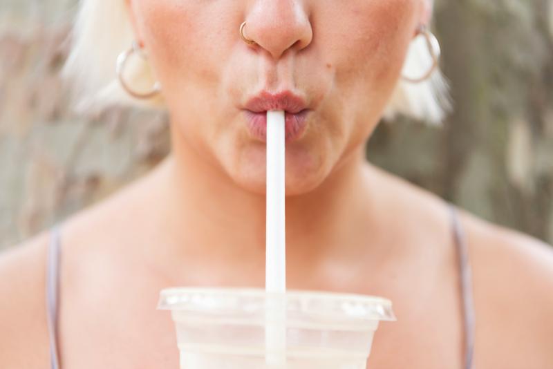 woman sipping iced coffee through straw