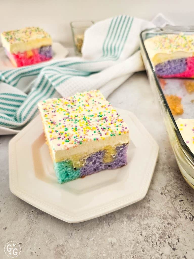 Rainbow Poke Cake for Spring on white plate