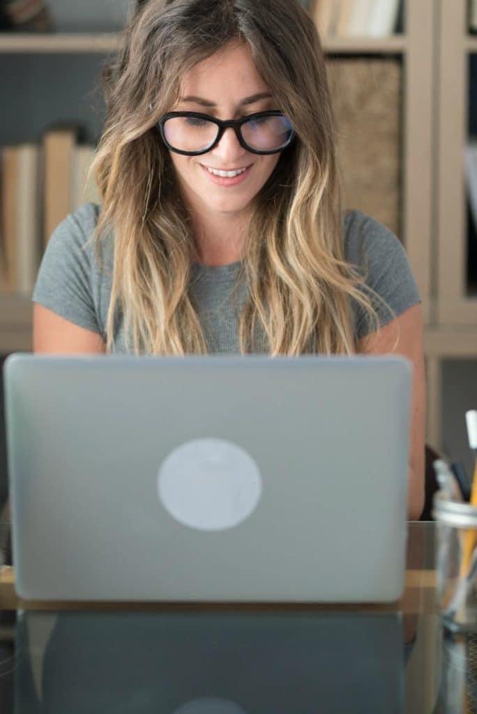 blonde woman with glasses using laptop