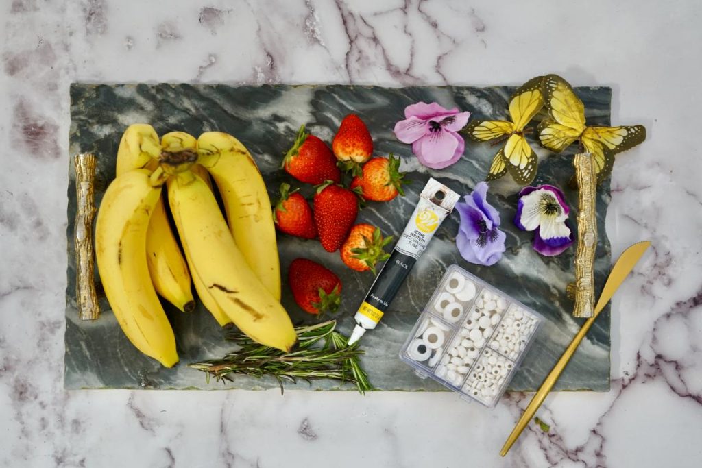 bananas, strawberries, candy eyes, and rosemary twigs for making butterfly fruit snacks